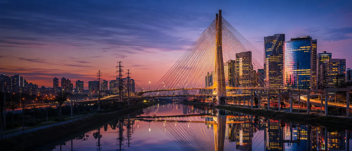 Distrito financeiro de São Paulo ao entardecer com a Ponte Estaiada Octávio Frias de Oliveira e as torres corporativas da Marginal Pinheiros — TaxUp, consultoria tributária para empresas