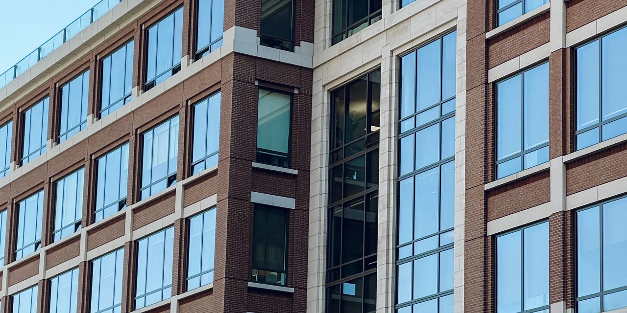 Fachada de edifício corporativo com janelas de vidro, usada para ilustrar a análise do destino de serviços digitais.