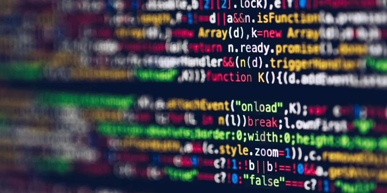 Linhas de código coloridas exibidas em detalhe na tela de um computador.